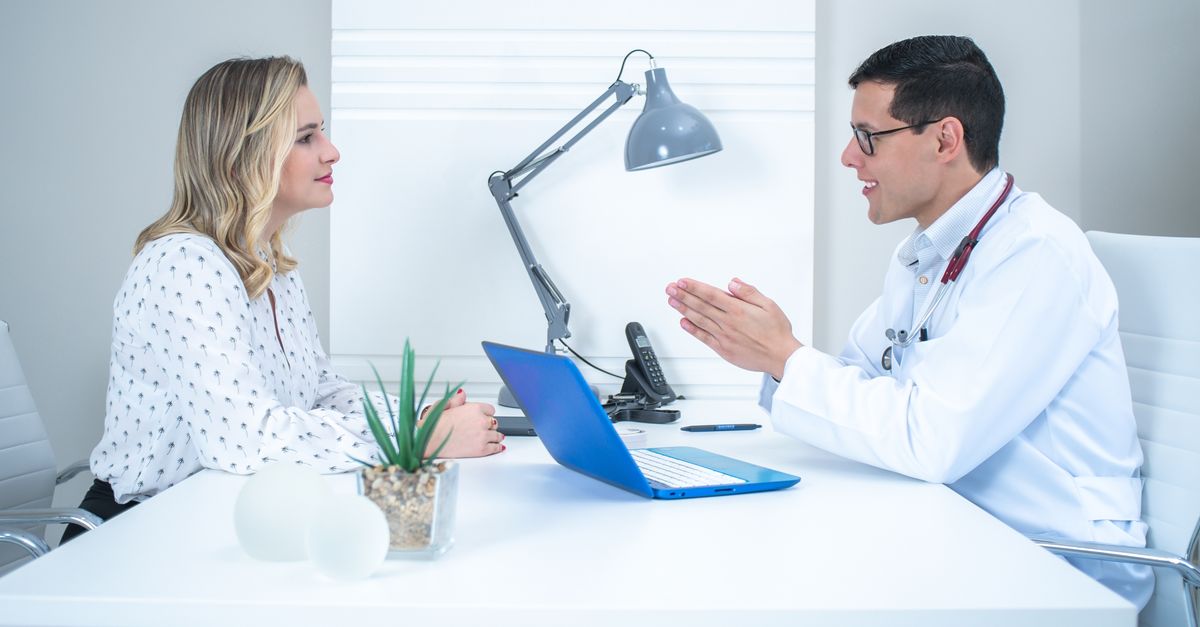 A doctor conducts a patient consultation in a bright, modern medical office.